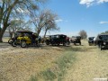 Tin Lizzies parked on the side of the road as Mark Dominguez makes adjustments to his carburetor