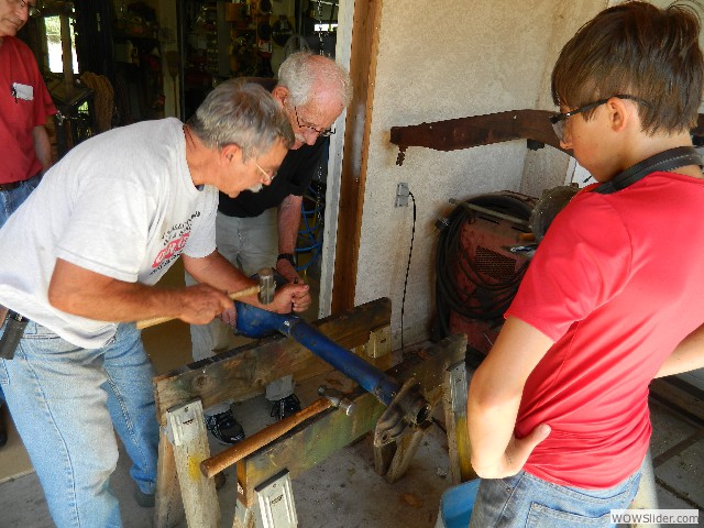 Larry, Don, and Cole focusing on salvaging a rear axle tube.