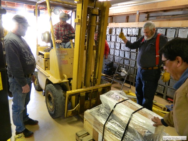 Larry using his forklift to load the engine into Bob's truck