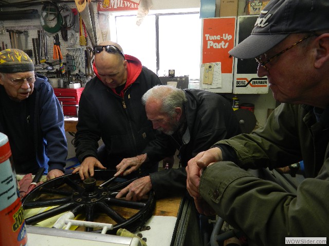 The O'Briens (Jeff and his father Neil) and Dean working on a wheel while Steve observes.