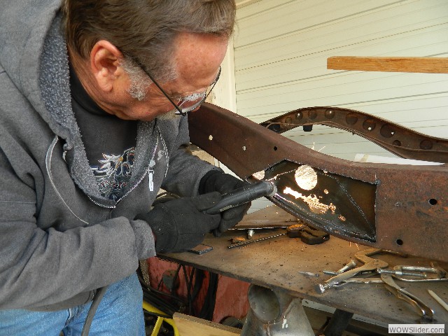 Joe using a plasma cutter to remove a rusted section from a 1940 truck frame.