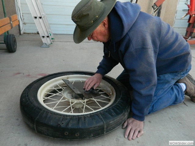 Neil figuring out how to create a bracket to mount a spare tire on Bob's car.