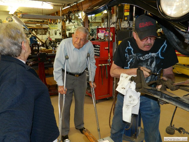 Betty talking to Bob as Michael works on Betty's steering components.